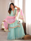 Model wearing the Mira mint embellished sharara suit set while holding the pink dupatta, full styling view.