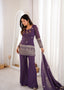 Model wearing the Isha purple bell bottom suit set while holding the matching dupatta, full styling view.