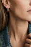 Model wearing Amber Flow Drops small gold plated amber resin drop earrings for everyday styling