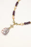 Close-up of crystal star charm and baroque pearl drop on amethyst and pearl necklace