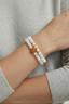 Model one hand close-up wearing Lotus Jade Wrap Bracelet triple wrap jade and pearl beaded bracelet
