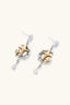 Angled view of mixed-metal star drop earrings with open silver frame and gold star detail
