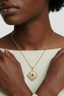 Model wearing Celestial Wisdom Pendant necklace, gold filigree medallion with lapis lazuli centre for elegant everyday styling