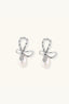 Angled view of bow stud earrings with baguette-style crystals and freshwater pearl drops