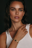 Women wearing gold bracelet with black mother of pearl centre