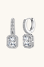 Sterling silver emerald cut moissanite drop earrings with pavé halo and huggie hoop, front view.