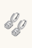 Close-up of sterling silver huggie earrings with rectangular emerald cut moissanite centre stone.