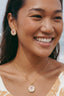 Model 2 wearing Garden Dream Studs small floral pearl studs in gold plated finish