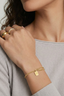 Minimal gold bracelet with small engraved lucky charm tag