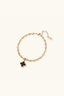 Front side of mother-of-pearl quatrefoil charm on gold-plated beaded bracelet