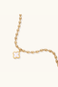 Close-up of mother-of-pearl quatrefoil charm on gold-plated beaded bracelet