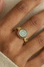 Model wearing gold plated evil eye statement ring with turquoise cubic zirconia