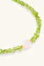 Close-up of green peridot chips and freshwater pearl on sterling silver bracelet