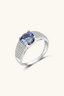 2 carat round moissanite sterling silver ring with pavé band on neutral background