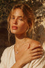 Model 2 wearing Rose Garden Heart Necklace – 18K gold plated enamel heart and pearl pendant sitting at the neckline