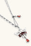 Detail of adjustable necklace slider with small red teardrop charm and crown pendant