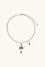 Close-up of crown pendant necklace showing red enamel and sparkling zirconia details