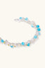 Close-up of hand-wrapped gemstone cuff bracelet with bright blue beads, blush stones, pearls and fine wire detailing
