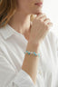 Model wearing pastel gemstone cuff bracelet with blue and blush stones styled with a white shirt